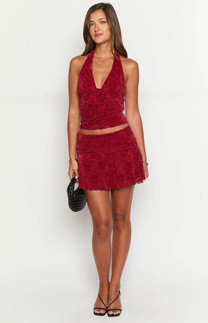 Red velvet mini skirt featuring a ruched waistband and subtle floral texture